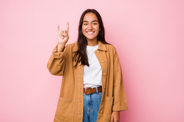 Young mixed race indian woman isolated showing a horns gesture as a revolution concept.