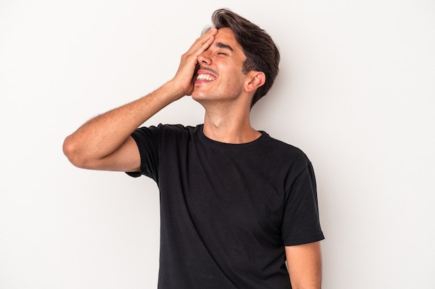 Young mixed race man isolated on white background laughing happy, carefree, natural emotion.