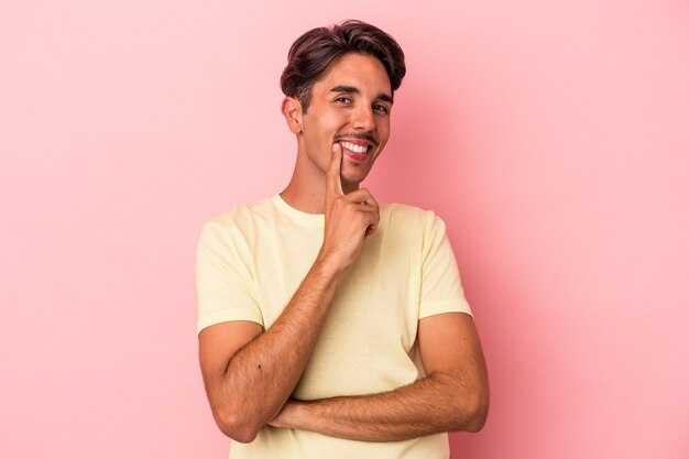 Young mixed race man isolated on white background smiling happy and confident, touching chin with hand.