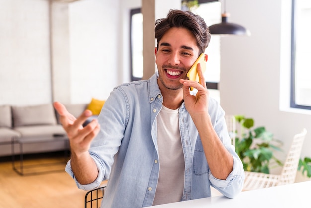 Young mixed race man talking on the phone in a kitchen