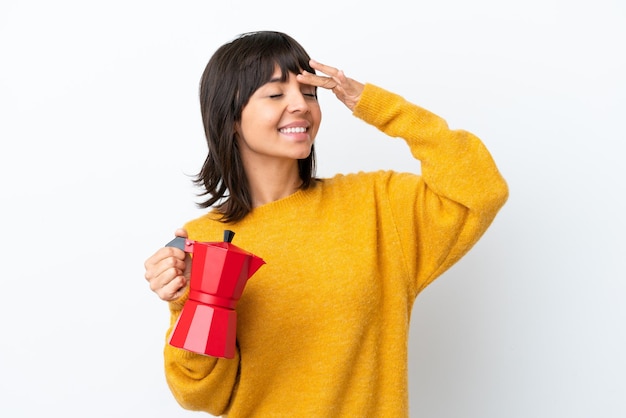 Young mixed race woman holding coffee pot isolated on white background smiling a lot