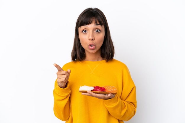 Young mixed race woman holding sashimi isolated on white background intending to realizes the solution while lifting a finger up