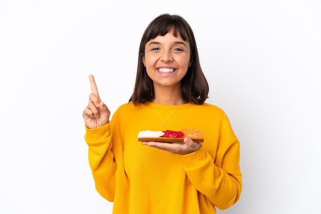 Young mixed race woman holding sashimi isolated on white background pointing up a great idea