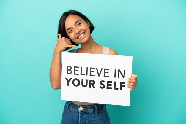 Young mixed race woman isolated holding We Want You board and making phone gesture