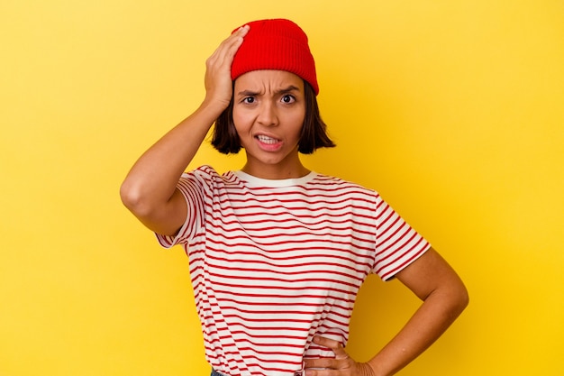 Young mixed race woman isolated on yellow background being shocked, she has remembered important meeting.