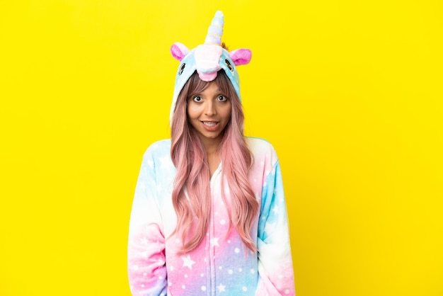 Young mixed race woman wearing a unicorn pajama isolated on white background with surprise facial expression