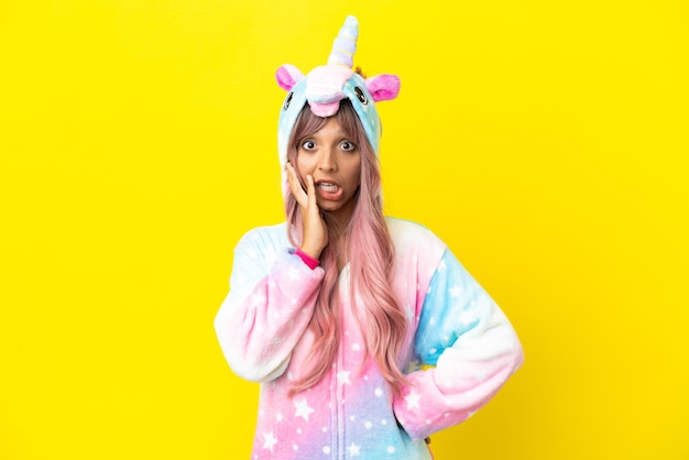 Young mixed race woman wearing a unicorn pajama isolated on white background with surprise and shocked facial expression