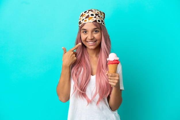 Young mixed race woman with a cornet ice cream isolated on blue background giving a thumbs up gesture