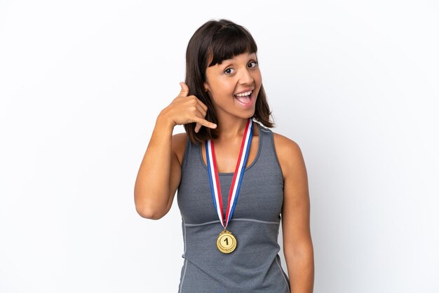 Young mixed race woman with medals isolated on white background making phone gesture. Call me back sign