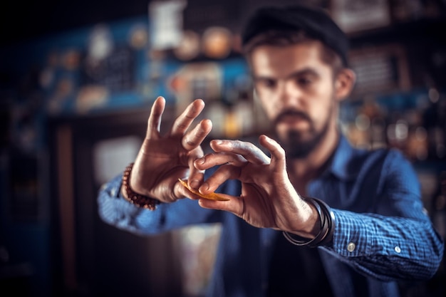 Young mixologist demonstrates his skills over the counter in the nightclub