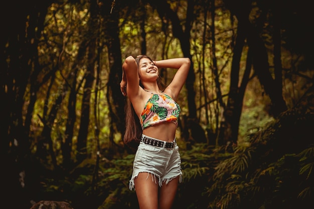 Young model in the forest in fashionable clothes