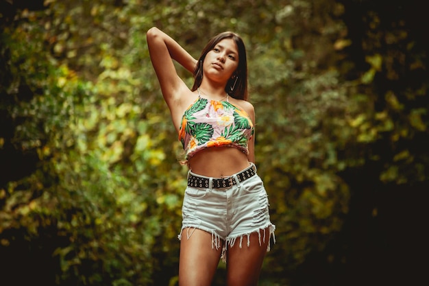 Young model in the forest in fashionable clothes