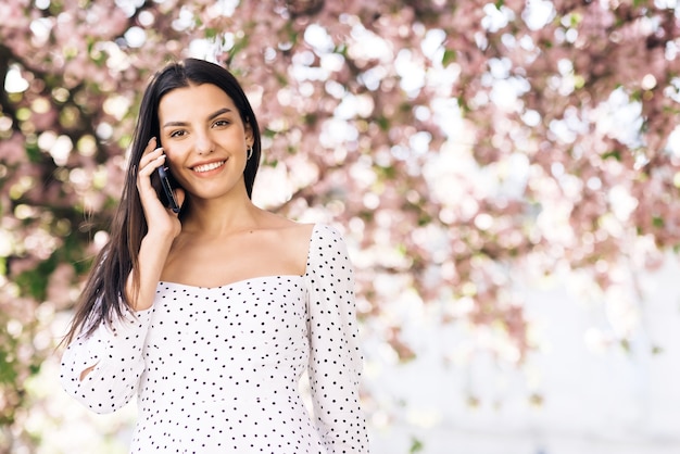 young model girl  talking on the phone walking in the park