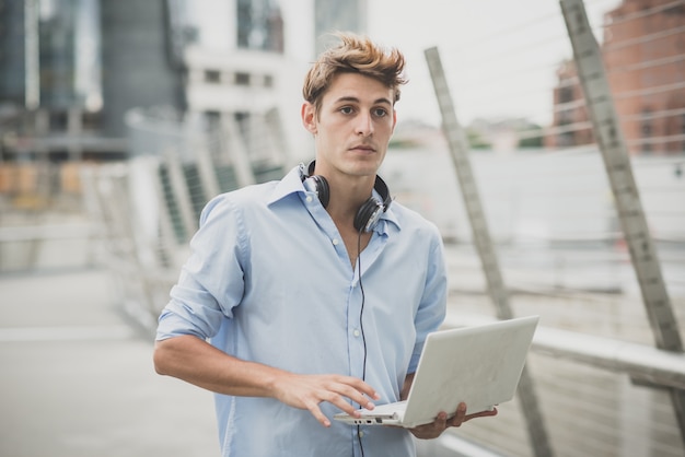 young model hansome blonde man with notebook and headphones