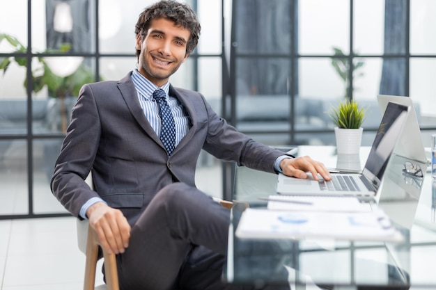 Young modern business man working using computer while sitting in the office