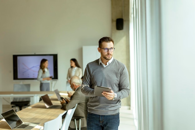 Young modern businessman using digital tablet in the office