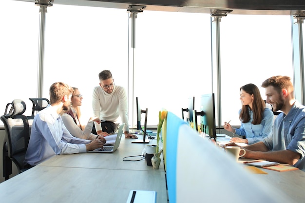 Photo young modern colleagues in smart casual wear working together while spending time in the creative office.