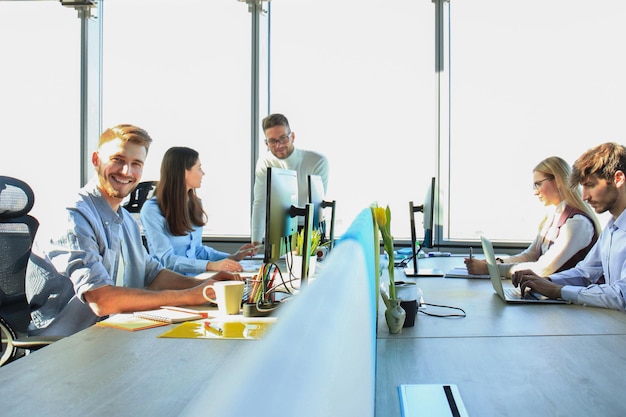 Photo young modern colleagues in smart casual wear working together while spending time in the creative office