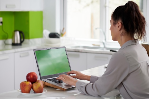 Young modern female creative designer or programmer typing on keypad of laptop