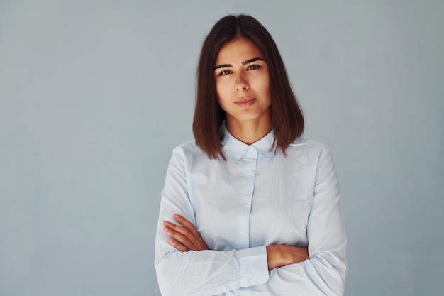 Young modern woman in white shirt standing inside of the studio