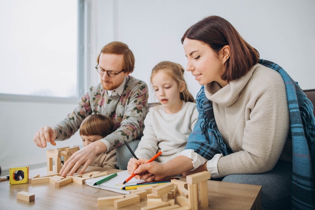 Young mom and dad play educational games with children