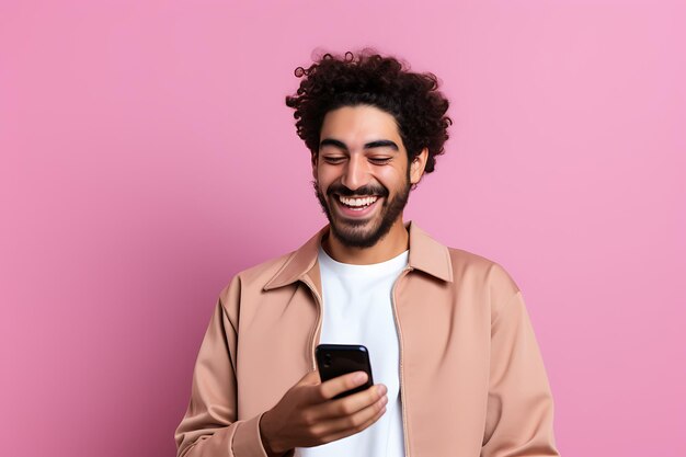 Young moroccan man using mobile phone isolated on pink wall smiling a lot