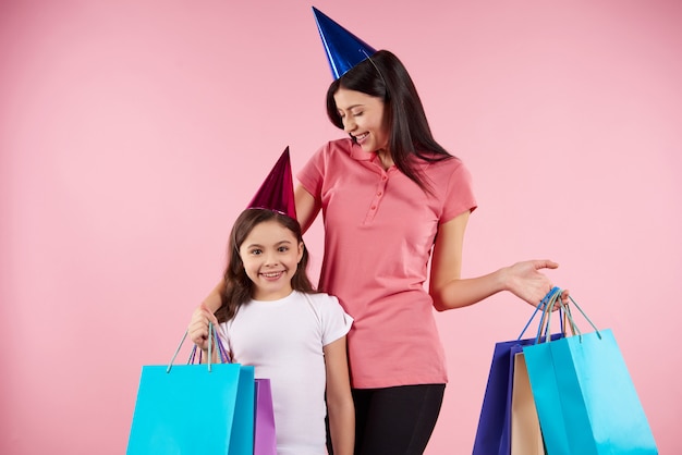 Young mother and daughter in party caps