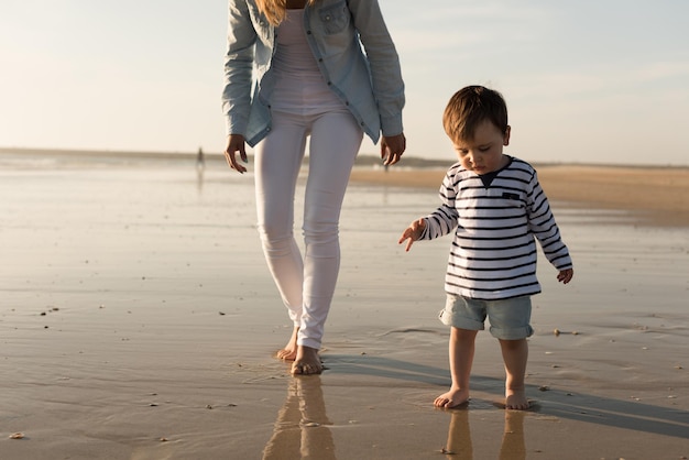 Young mother exploring the beach with toddler