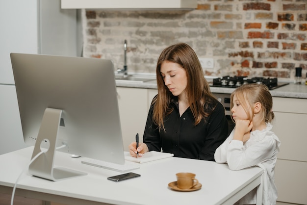 Young mother helping her daughter with homework