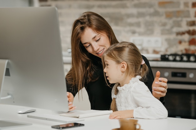 Young mother helping her daughter with homework