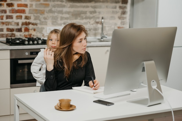 Young mother helping her daughter with homework