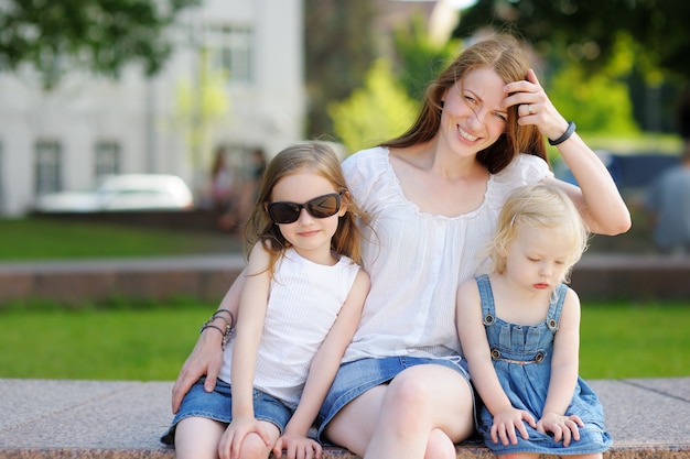 Young mother and her daughters outdoors at summer