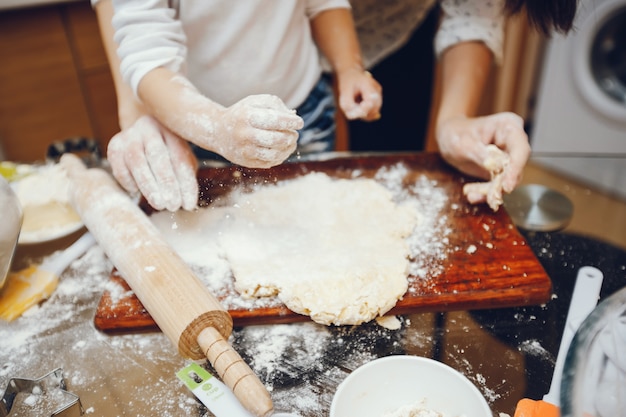 a young mother is preparing food at home in the kitchen with her little son