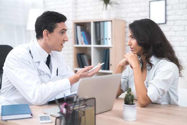 A young mother is talking to a doctor in his doctor's office