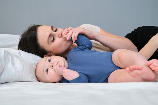 Young mother lovingly kisses her son toddler