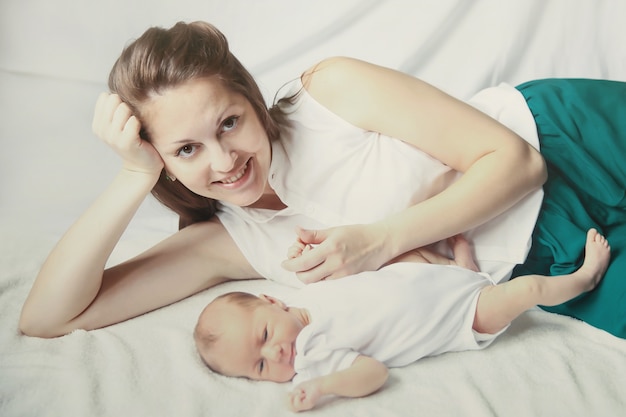 Young mother and a newborn baby lying on the couch