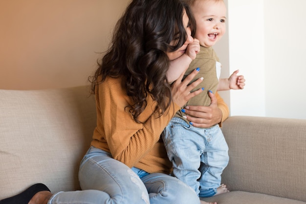 Young mother playing with her baby at home