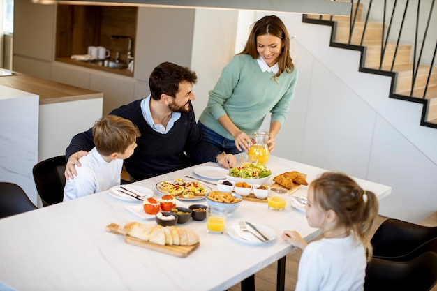 Young mother preparing breakfast for her family in the modern kitchen