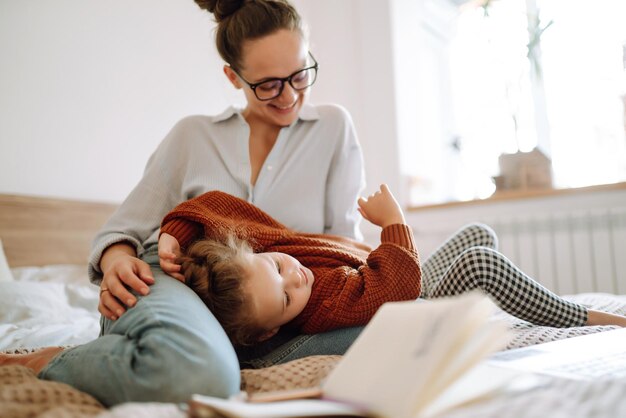 Young mother talking on the phone and discussing work issues while looking after her child Covid19