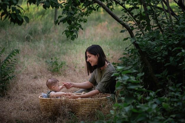 Young mother walks with baby daughter in the green park.