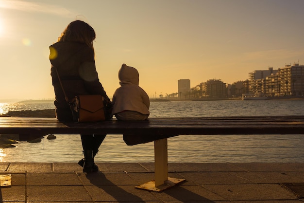 A young mother with her baby at sunset on Playa del Cura in the coastal town of Torrevieja