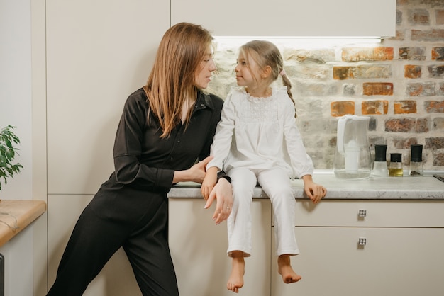 Young mother with her daughter in the kitchen