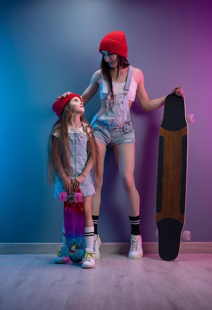 A young mother with her daughter on a skateboard and a longboard