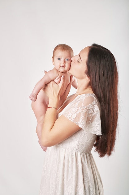 young mother with natural make-up holds the baby in her arms