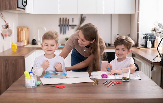 A young mother and young children preschool sons do homework