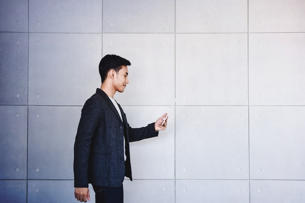 Young motivation Businessman Reading Message via Tablet while Walk