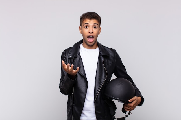 Young motorbike rider looking desperate and frustrated, stressed, unhappy and annoyed, shouting and screaming