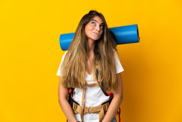 Young mountaineer woman with a big backpack isolated