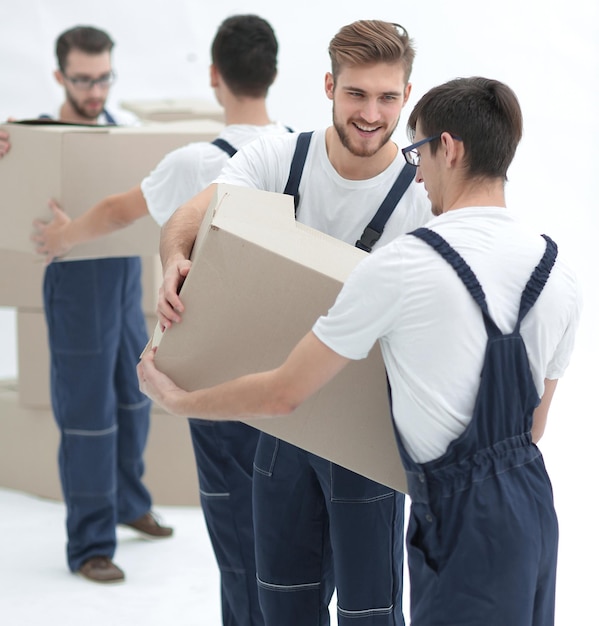 Young movers holding boxes standing in a row isolated on white background