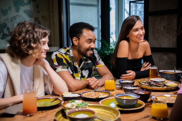 Young multi-ethnic friends celebrating something in a cafe